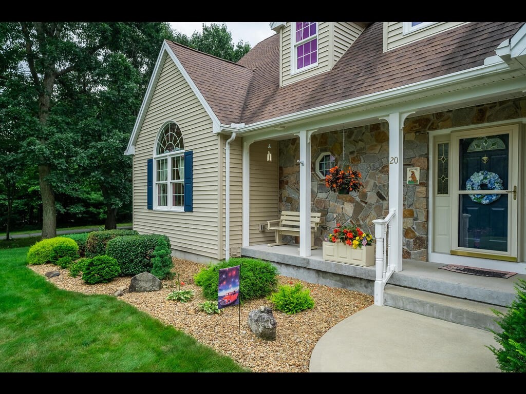 20 Paradise Lake Road Monson, MA 01057 - Photo 3 of 42 a view of a white house with potted plants and a large tree