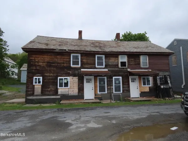 a view of a brick house with a yard
