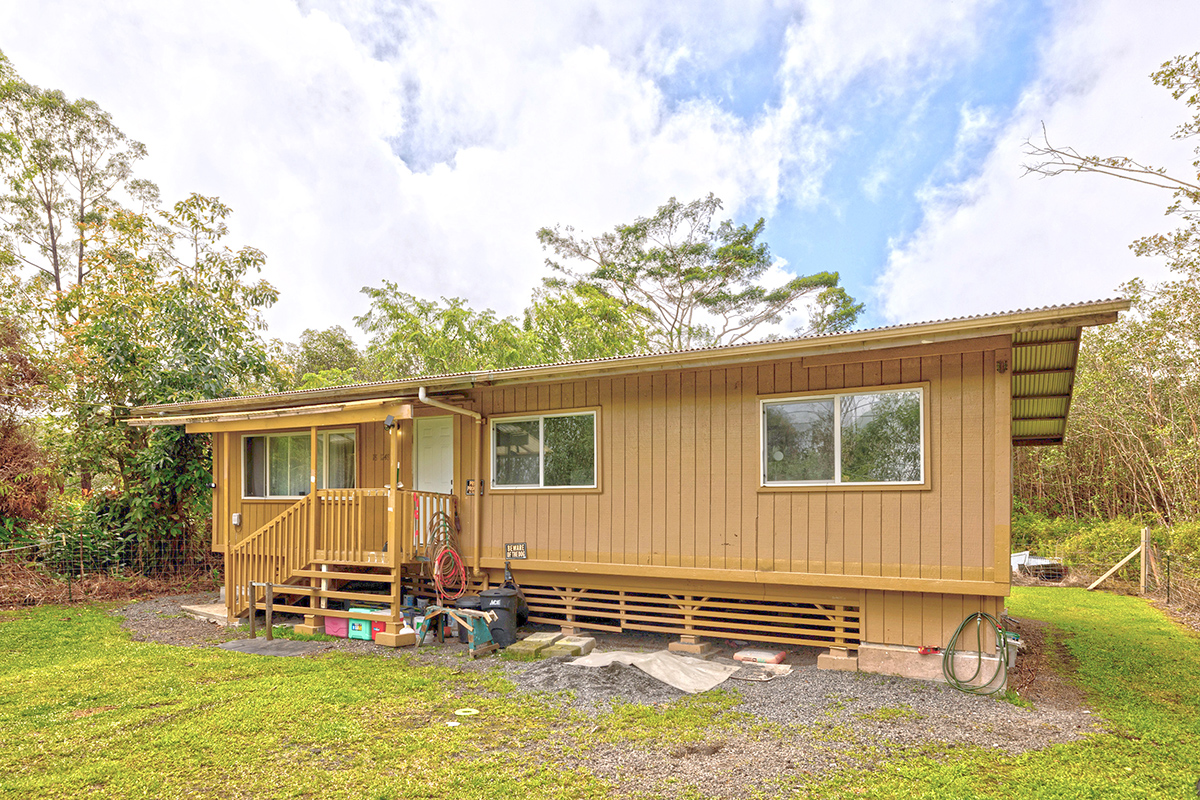 a view of a house with backyard and a large tree