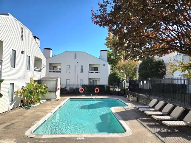 a view of a white house with a yard siting area and garden