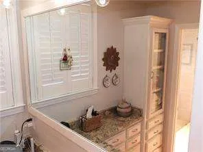 a bathroom with a granite countertop sink and a window