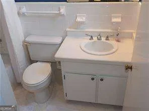 a white toilet sitting next to a bathroom sink