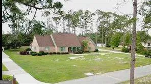a view of a house with a big yard potted plants and large tree