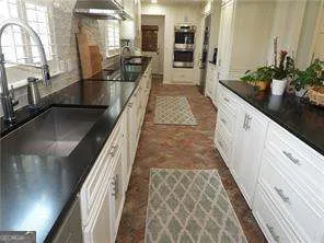 a hallway with white cabinets and potted plant