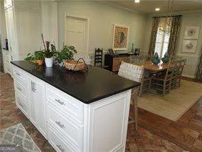 a kitchen with granite countertop a table and chairs in it