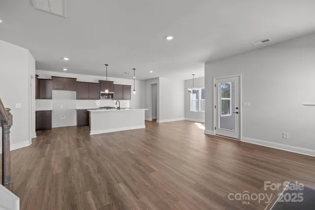 a view of a kitchen with wooden floor and a window