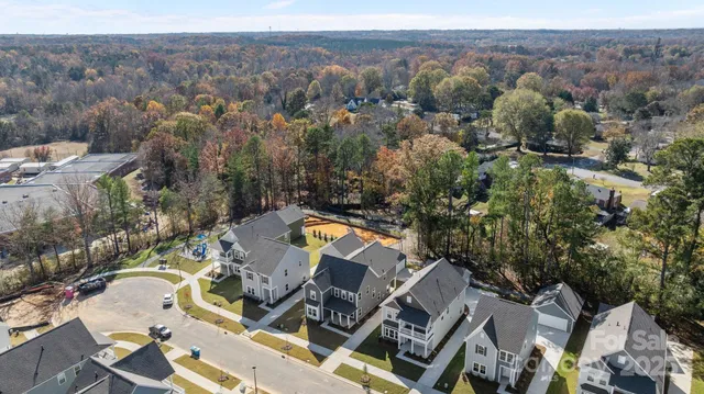 an aerial view of a house with a mountain