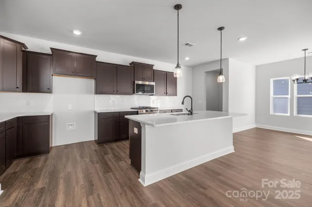 a large kitchen with stainless steel appliances granite countertop a stove a sink and a refrigerator