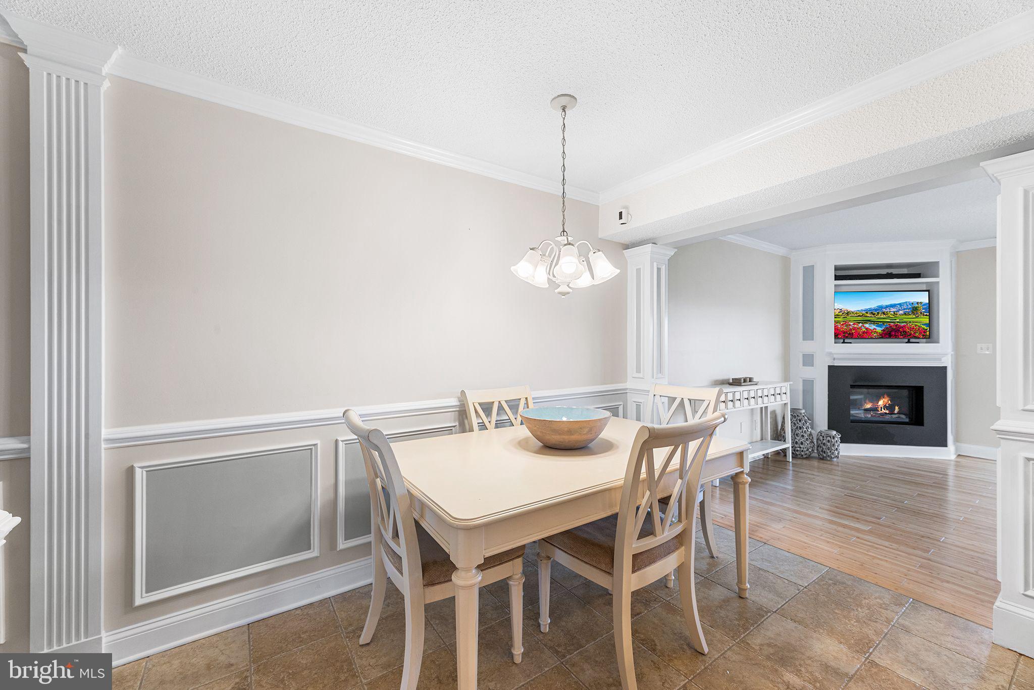 772 94th Street, Unit A Ocean City, MD 21842 - Photo 18 of 36 a view of a dining room and livingroom with furniture wooden floor a rug a chandelier and a mirror