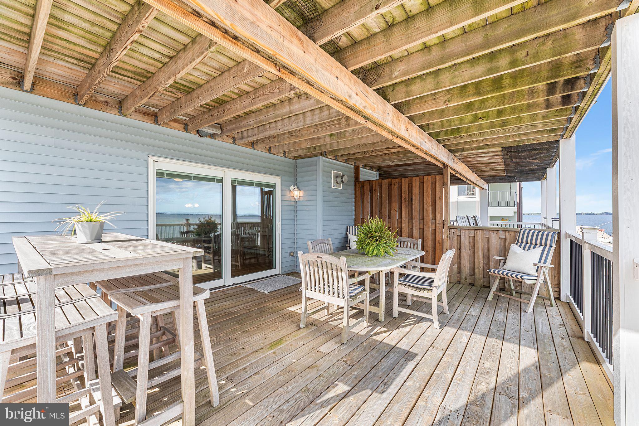 772 94th Street, Unit A Ocean City, MD 21842 - Photo 30 of 36 a view of a patio with table and chairs and wooden floor