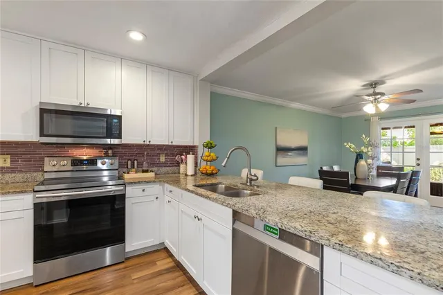 a kitchen with sink a stove and cabinets