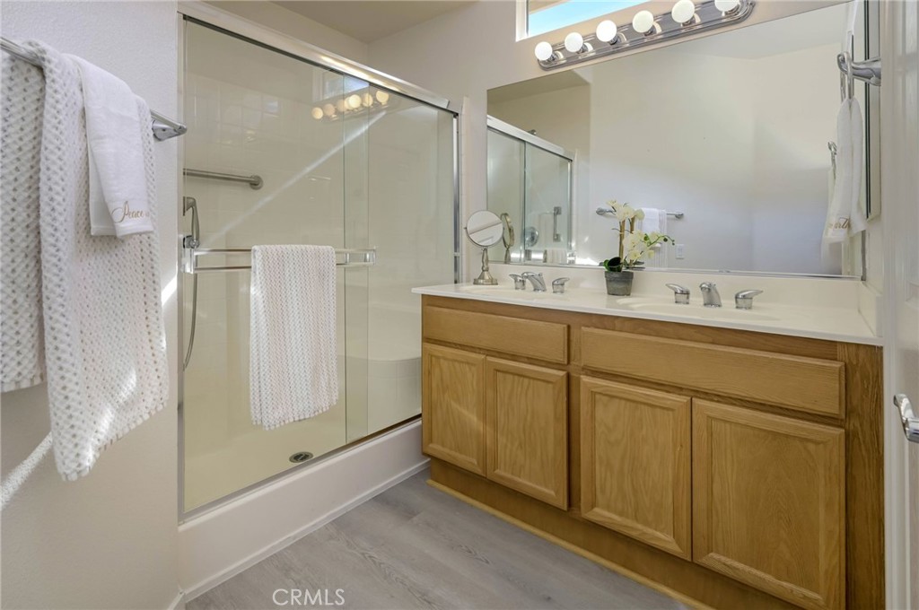9141 Filaree Court Corona, CA 92883 - Photo 24 of 54 a bathroom with a double vanity sink mirror and shower