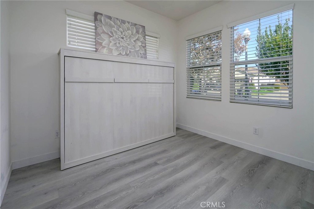 9141 Filaree Court Corona, CA 92883 - Photo 28 of 54 an empty room with wooden floor and windows
