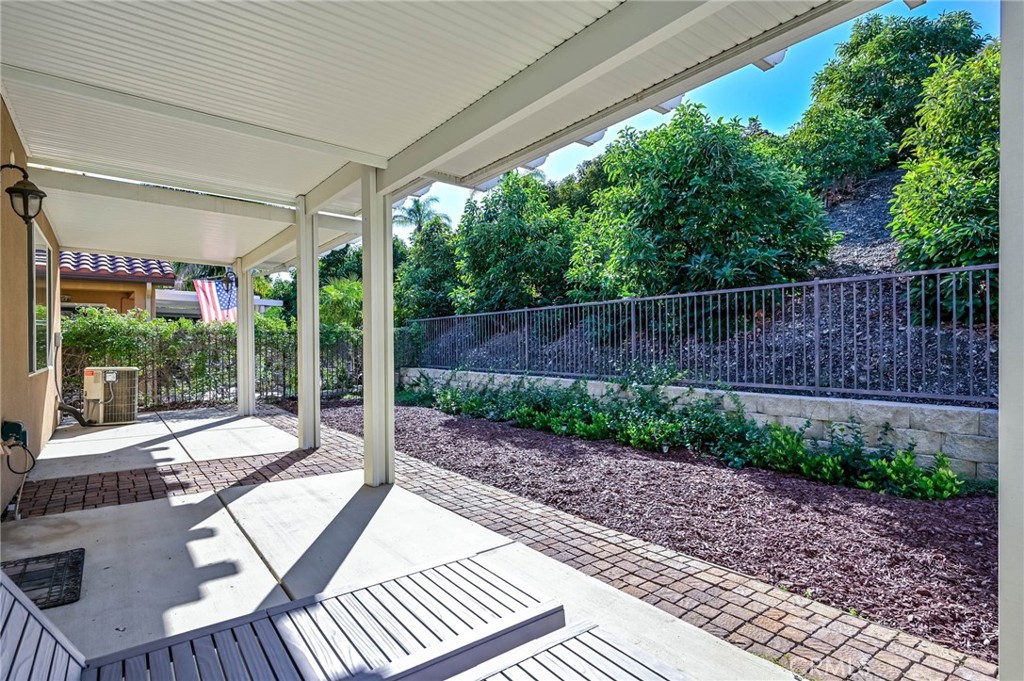 9141 Filaree Court Corona, CA 92883 - Photo 35 of 54 a view of a patio with a table chairs and a backyard