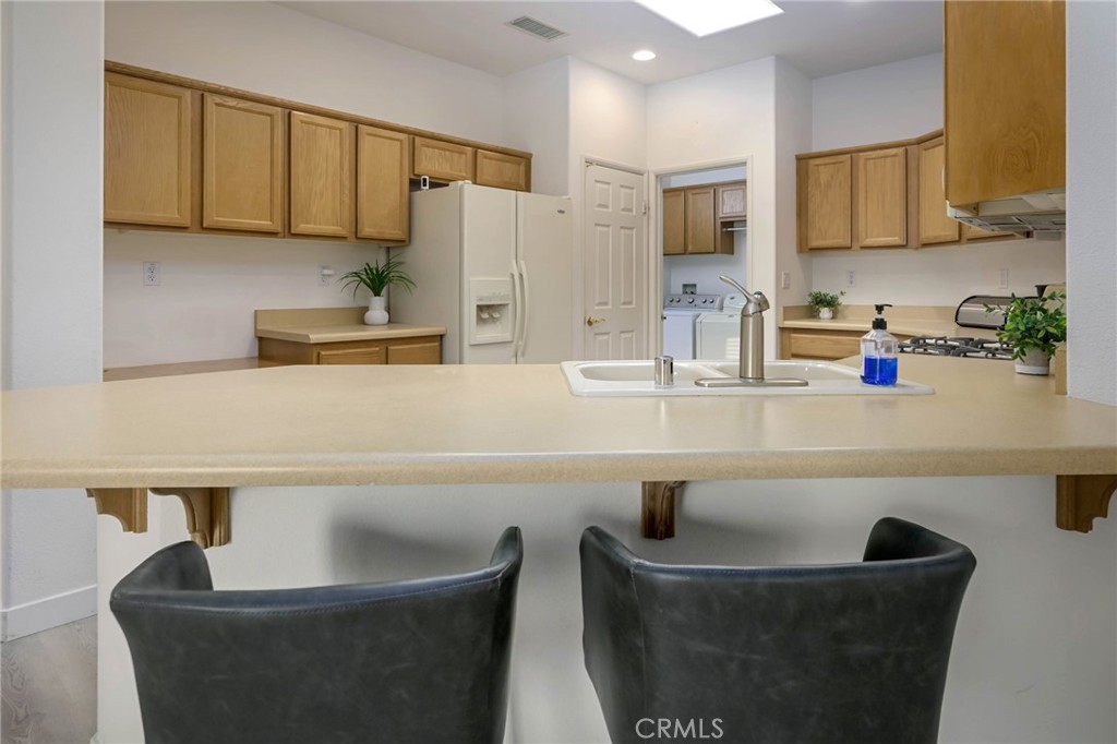 9141 Filaree Court Corona, CA 92883 - Photo 10 of 54 a kitchen with a sink a stove and a refrigerator