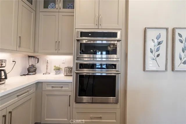 a kitchen with granite countertop white cabinets and stainless steel appliances