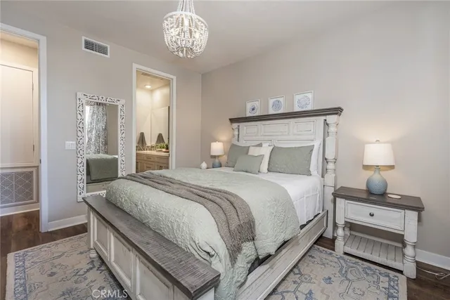 a bedroom with bed and a table with chair