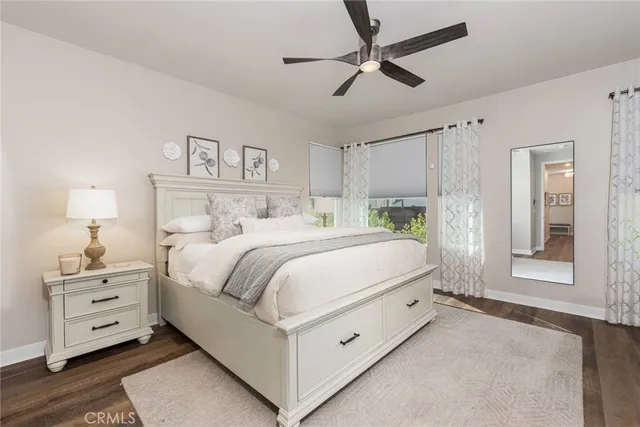 a bedroom with a bed and a lamp on the dresser