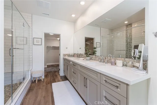 a bathroom with a double vanity sink mirror and shower