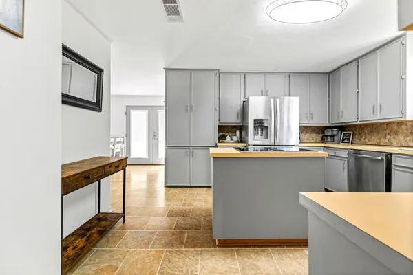 a kitchen with stainless steel appliances granite countertop a refrigerator sink and cabinets