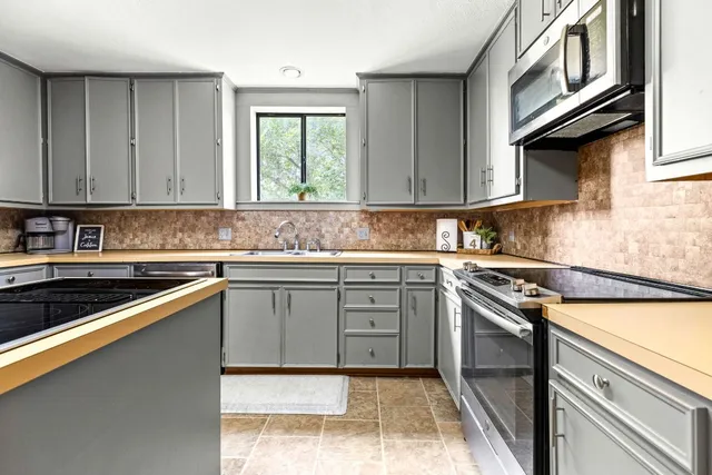 a kitchen with stainless steel appliances granite countertop a stove and a sink