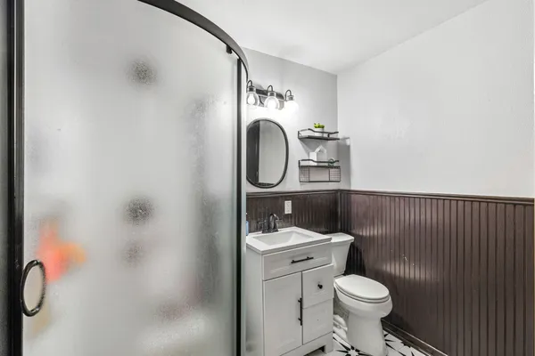 a bathroom with a toilet sink vanity and mirror