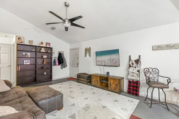a living room with furniture a ceiling fan and a bookshelf