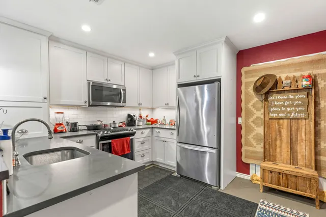 a kitchen with stainless steel appliances granite countertop a refrigerator sink and stove