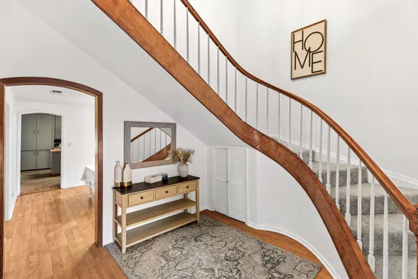 a view of staircase with wooden floor and a rug