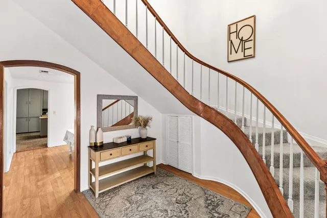 a view of staircase with wooden floor and a rug
