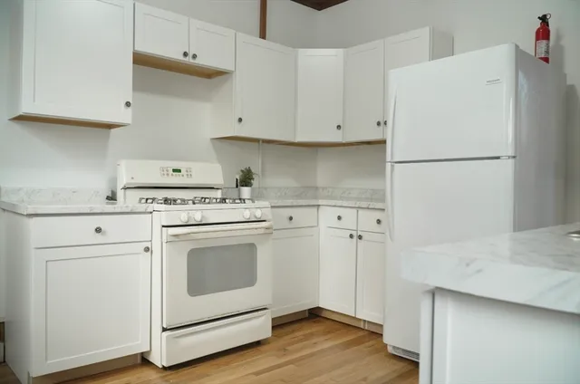 a kitchen with white cabinets and white appliances