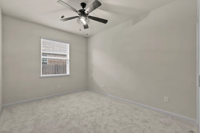 an empty room with a window and a fan