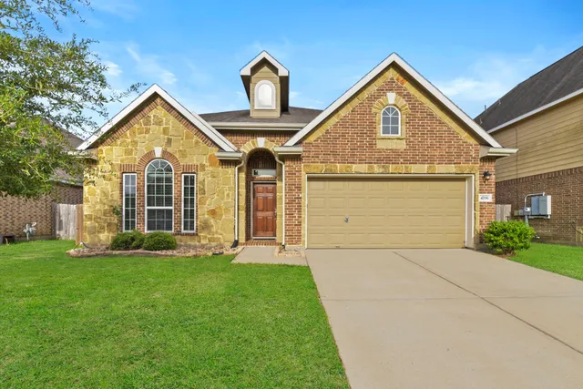 a front view of a house with a yard and garage