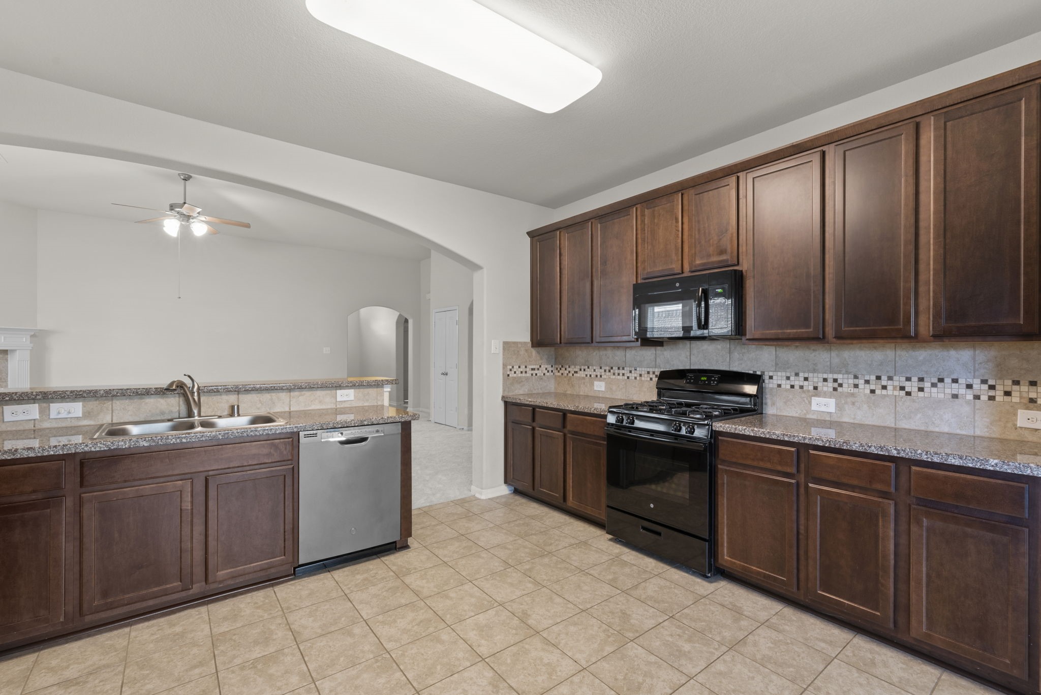 4706 Alluvial Circle Alvin, TX 77511 - Photo 6 of 39 a kitchen with stainless steel appliances granite countertop wooden cabinets a stove top oven a sink and dishwasher