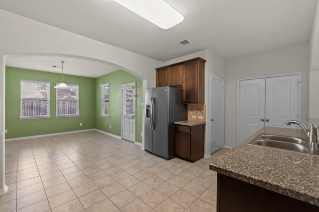 a kitchen with stainless steel appliances granite countertop a refrigerator and a sink