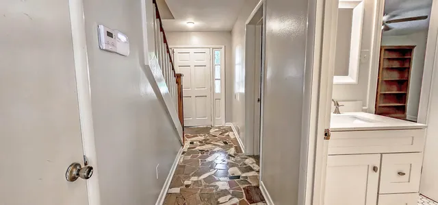 an empty room with wooden floor closet and windows