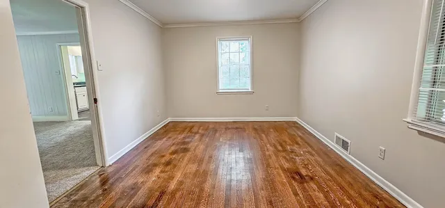 a view of a room with wooden floor and window