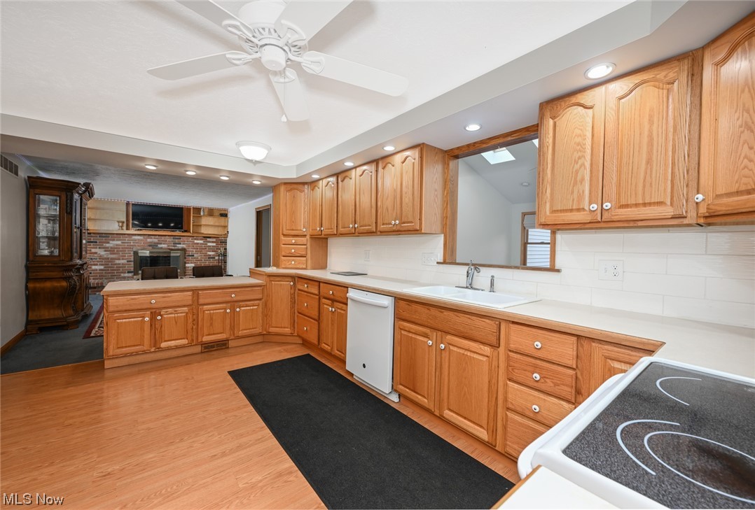4574 Fishcreek Road Stow, OH 44224 - Photo 19 of 49 Kitchen featuring light laminate / wood-style floors, ceiling fan, tasteful backsplash, dishwasher, and sink