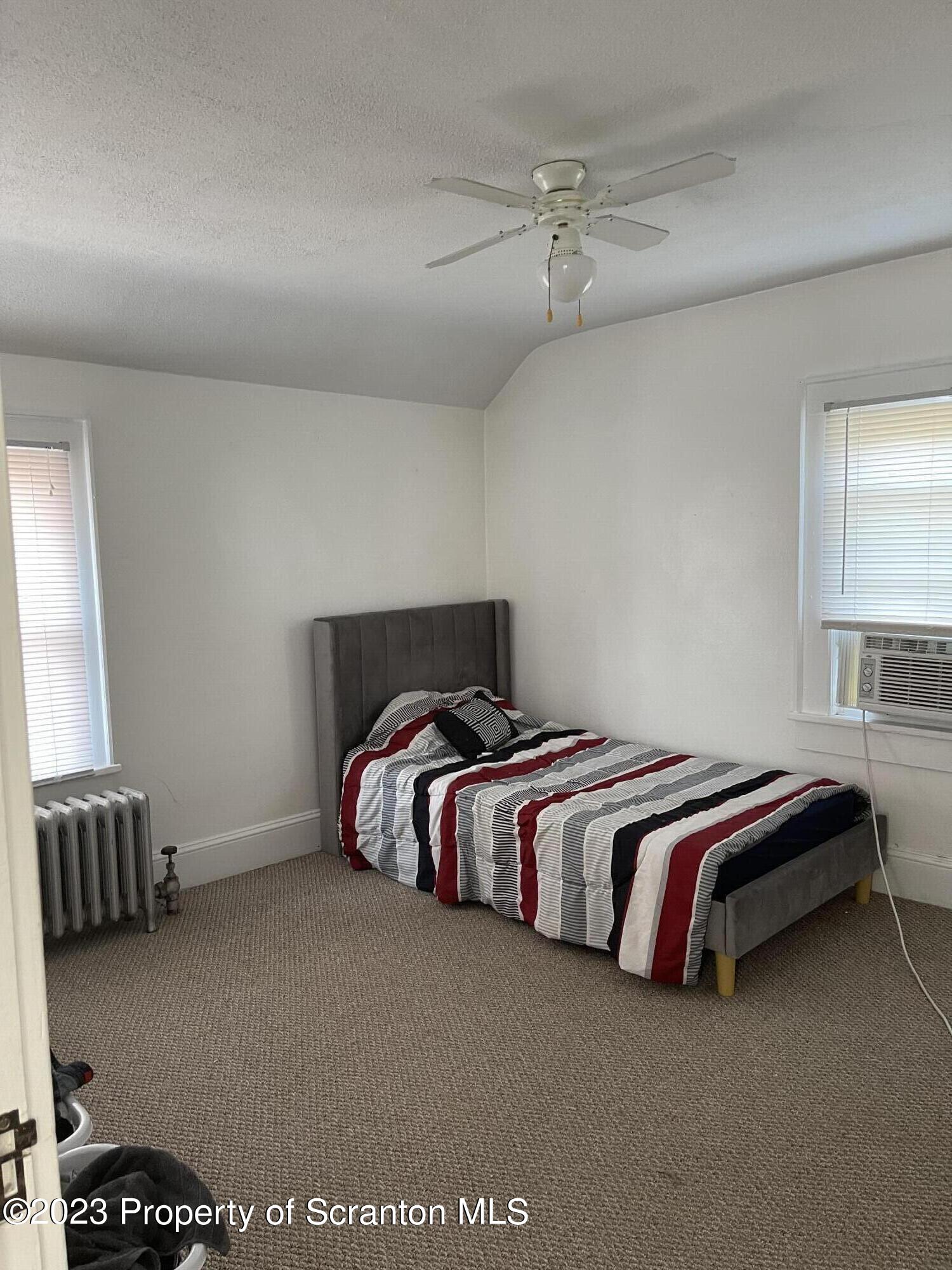 302 Rear Delaware Street Archbald, PA 18403 - Photo 13 of 20 a spacious bedroom with a bed and a window