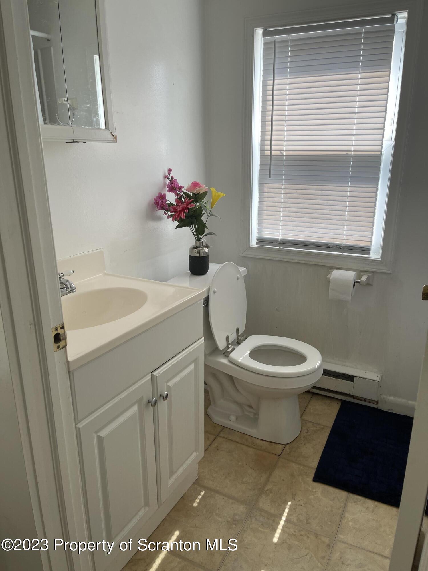 302 Rear Delaware Street Archbald, PA 18403 - Photo 16 of 20 a bathroom with a toilet a sink and a window