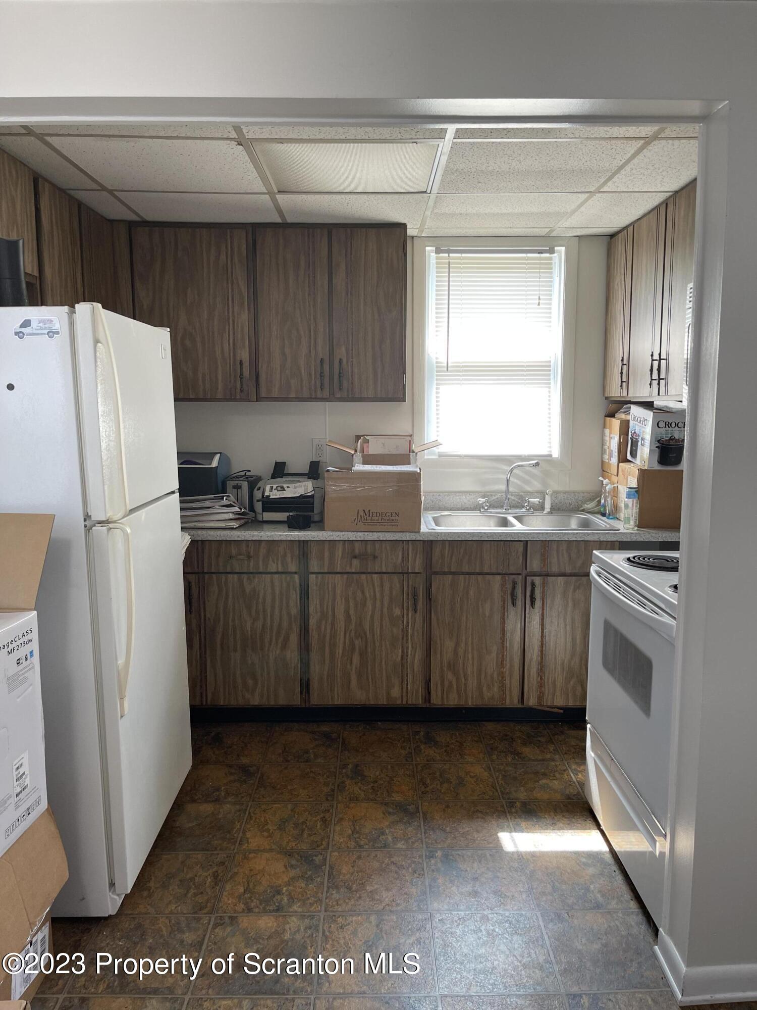 302 Rear Delaware Street Archbald, PA 18403 - Photo 6 of 20 a kitchen with stainless steel appliances granite countertop a refrigerator a sink a stove a microwave a counter space and cabinets