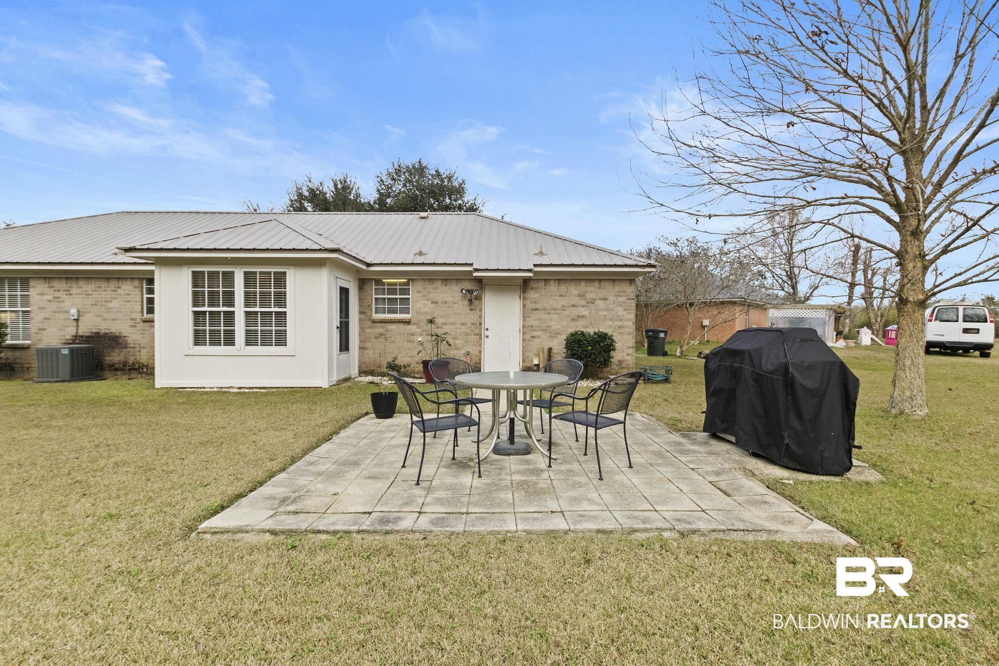 14031 Brook Hollow Road Summerdale, AL 36580 - Photo 54 of 56 Rear view of house featuring central AC, a yard, and a patio