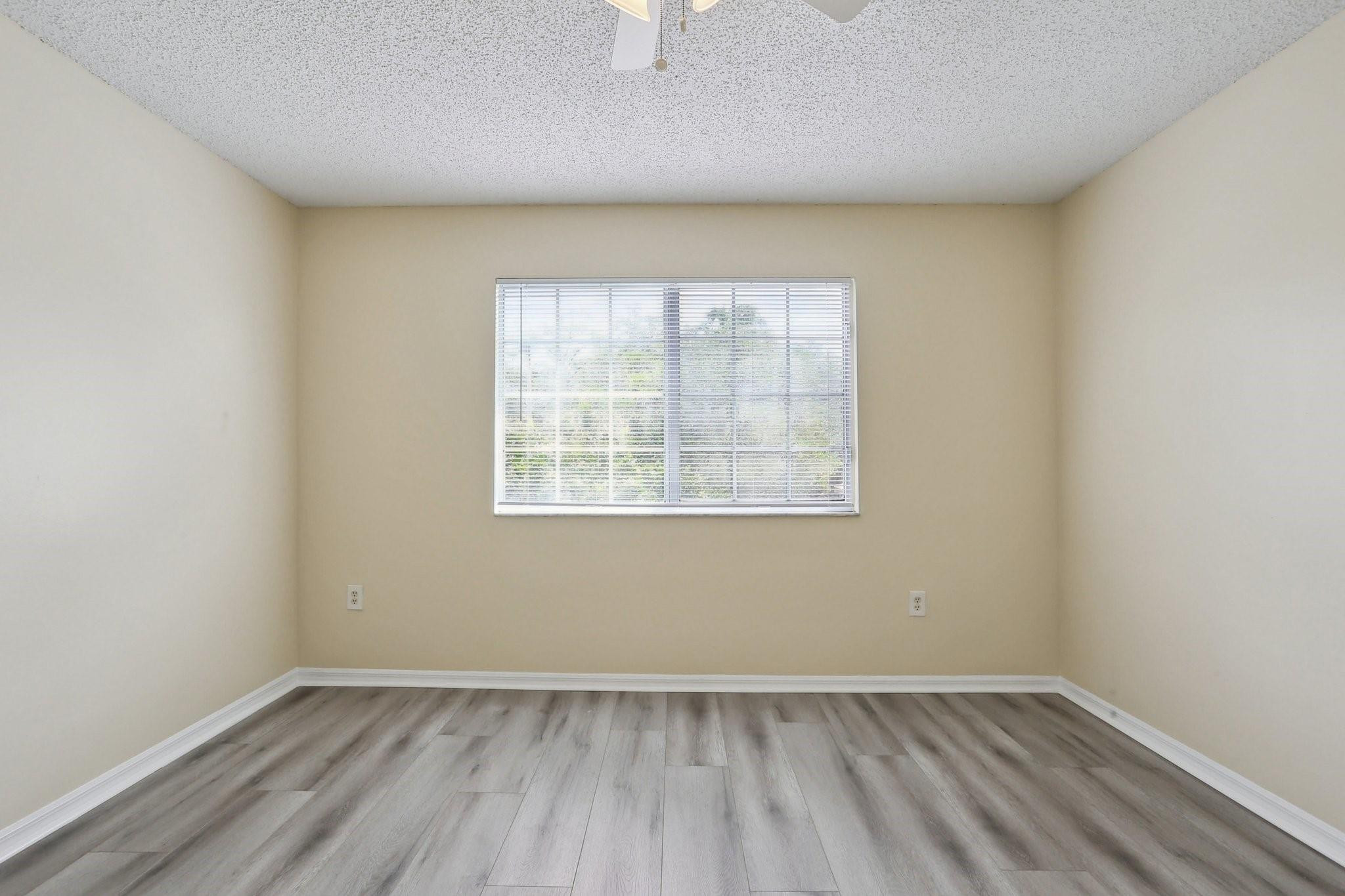 5051 Wiles Road, Unit 201 Coconut Creek, FL 33073 - Photo 23 of 41 an empty room with wooden floor and windows