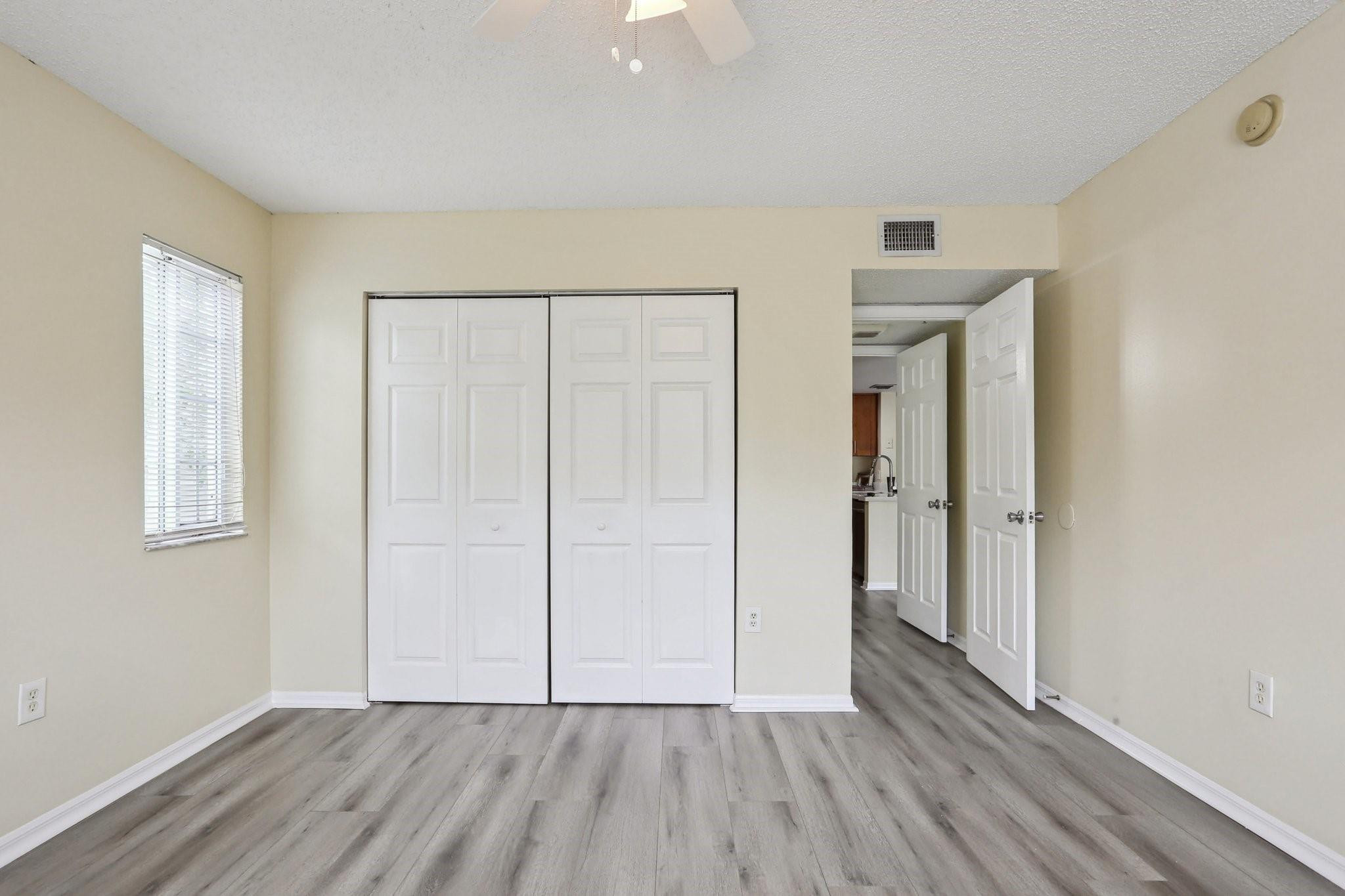 5051 Wiles Road, Unit 201 Coconut Creek, FL 33073 - Photo 26 of 41 a view of an empty room with closet and wooden floor