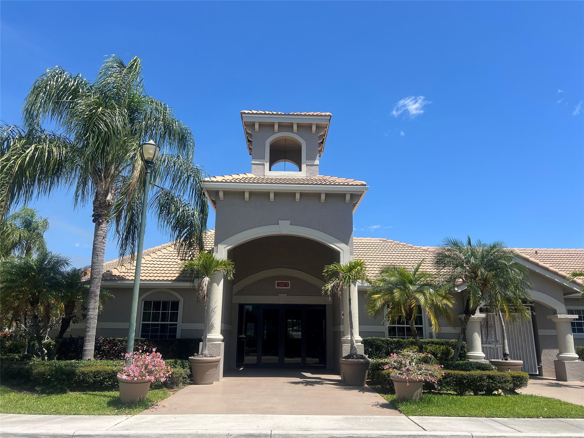 5051 Wiles Road, Unit 201 Coconut Creek, FL 33073 - Photo 37 of 41 a front view of a house with yard and garage