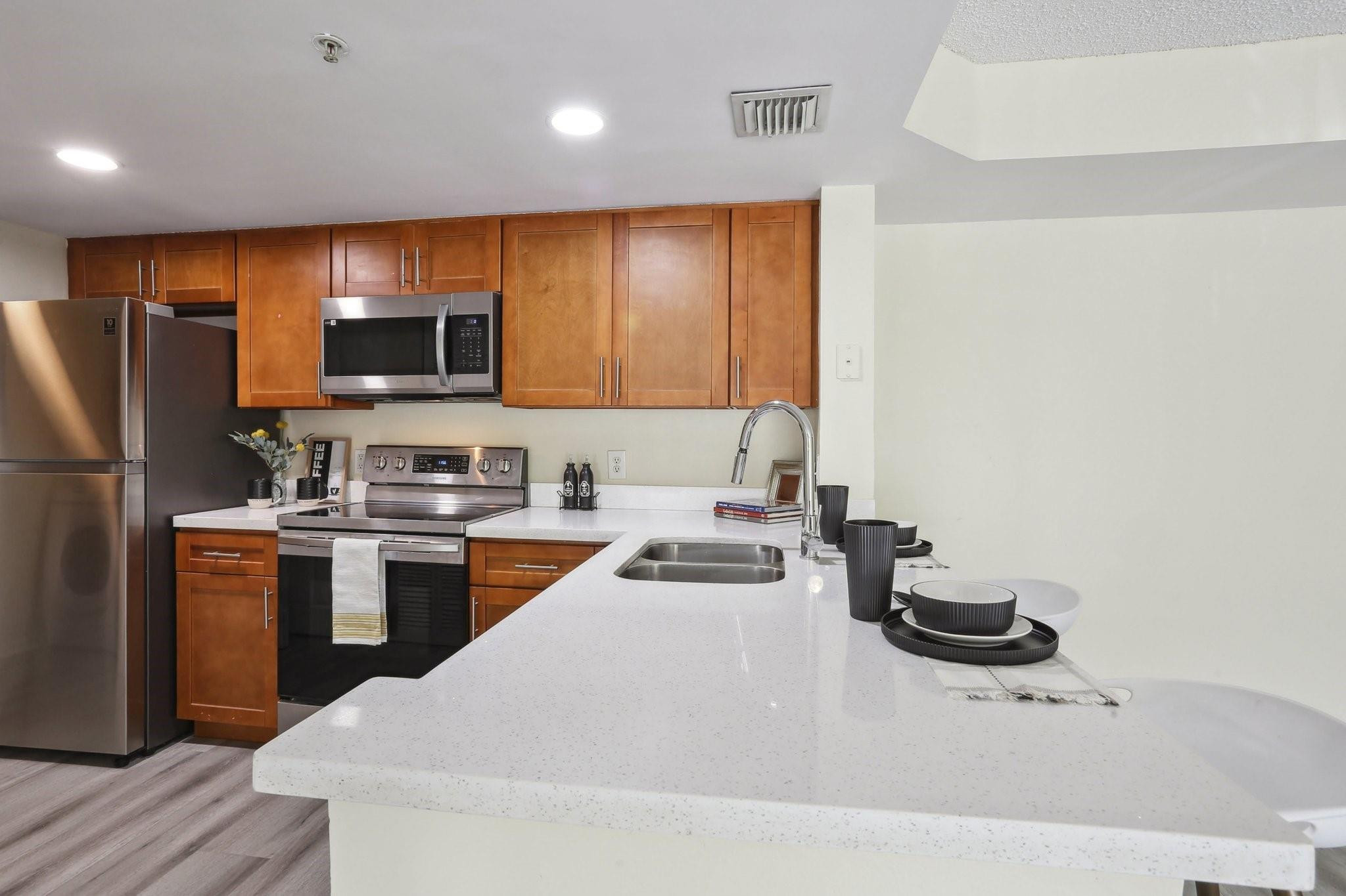 5051 Wiles Road, Unit 201 Coconut Creek, FL 33073 - Photo 5 of 41 a kitchen with a refrigerator and a stove top oven