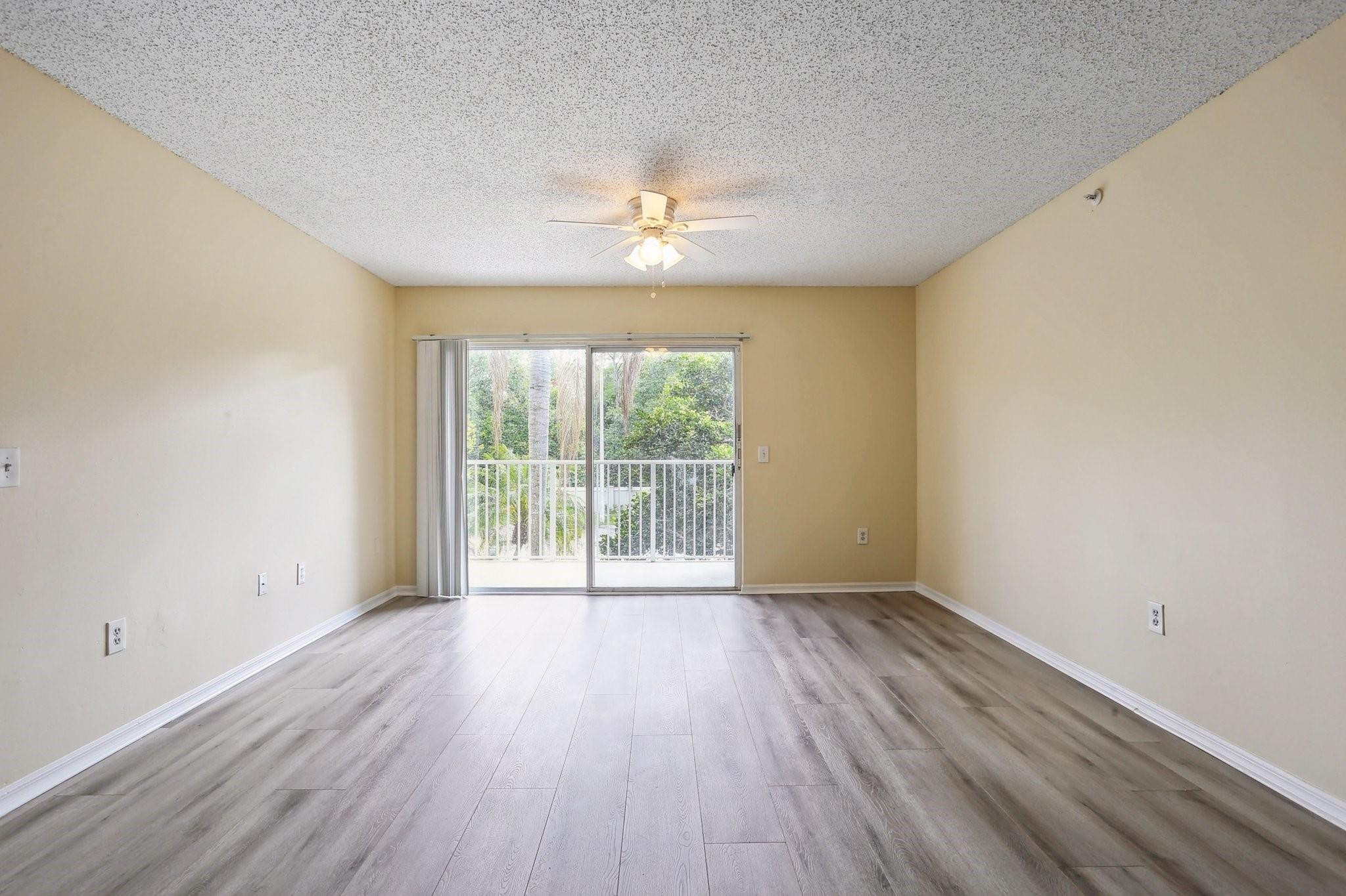5051 Wiles Road, Unit 201 Coconut Creek, FL 33073 - Photo 8 of 41 a view of an empty room with wooden floor and a window