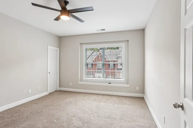 a view of a livingroom with a ceiling fan and window