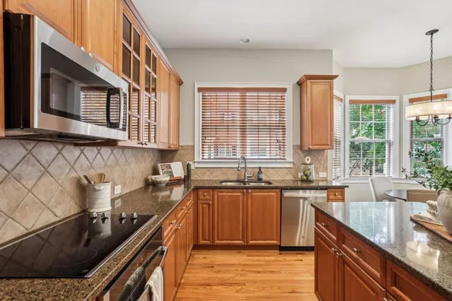 a kitchen with stainless steel appliances a sink stove and cabinets
