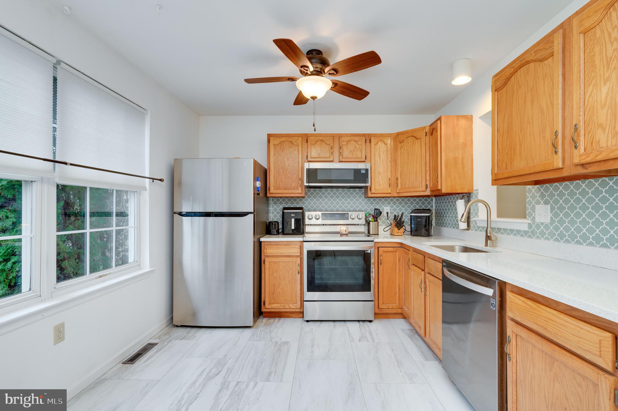 21-4 Cranberry Ridge, Unit 4 Reading, PA 19606 - Photo 7 of 41 a kitchen with stainless steel appliances granite countertop a refrigerator a stove a sink and a window with wooden floors
